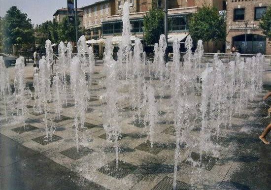 Rain dance fountain with people enjoying the water